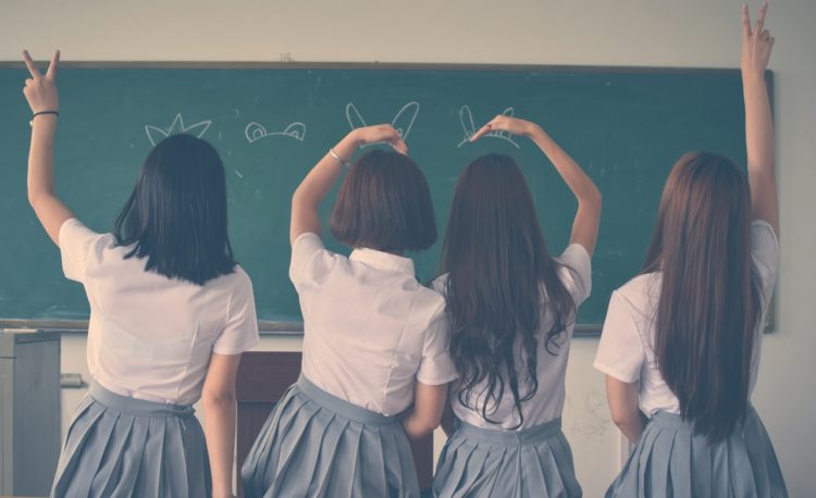 four female students doing hand sign