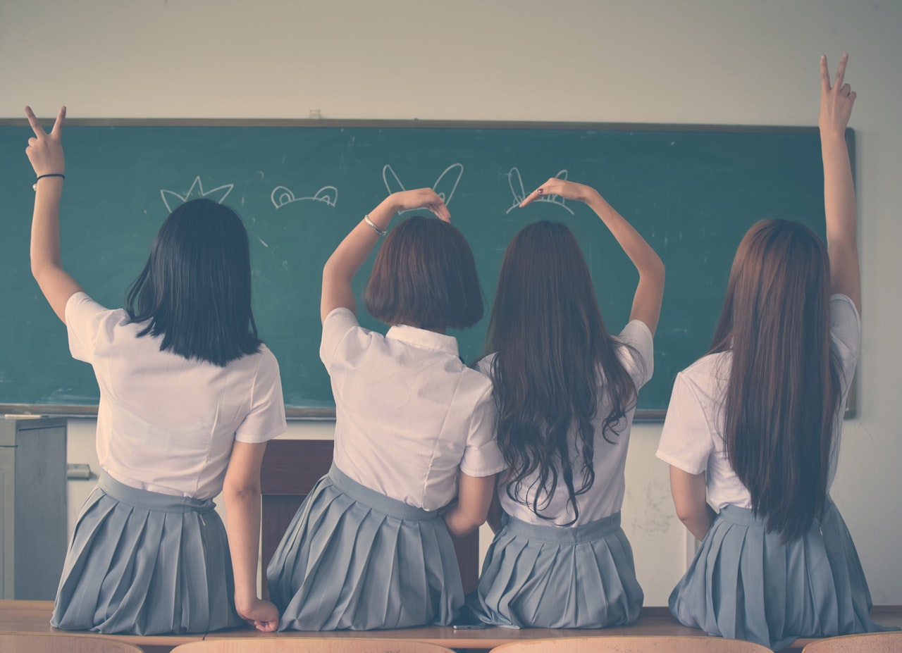 four female students doing hand sign
